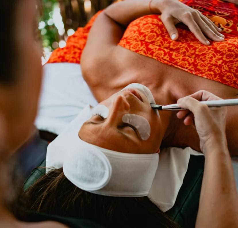 Therapist applying a natural facial treatment in the open-air cabana