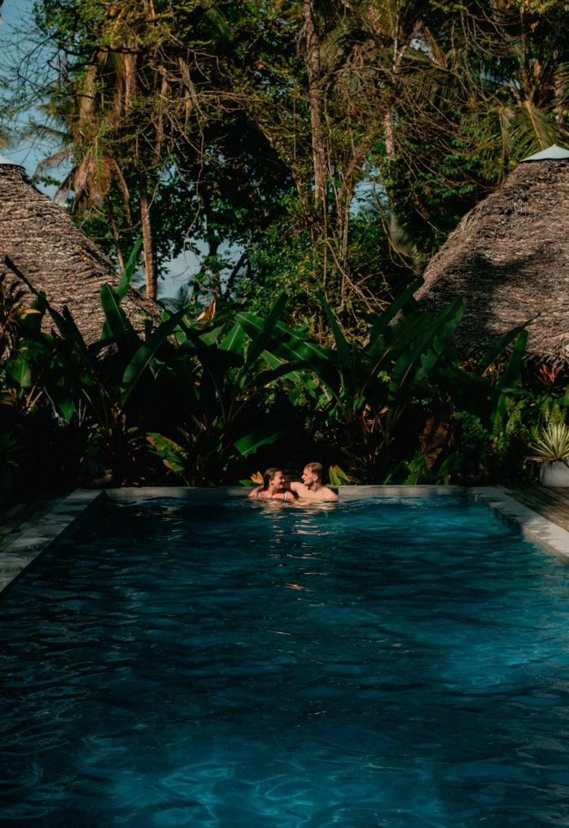 Jungle plunge pool with thatched-roof cabanas at Bluff Beach Jungle Spa