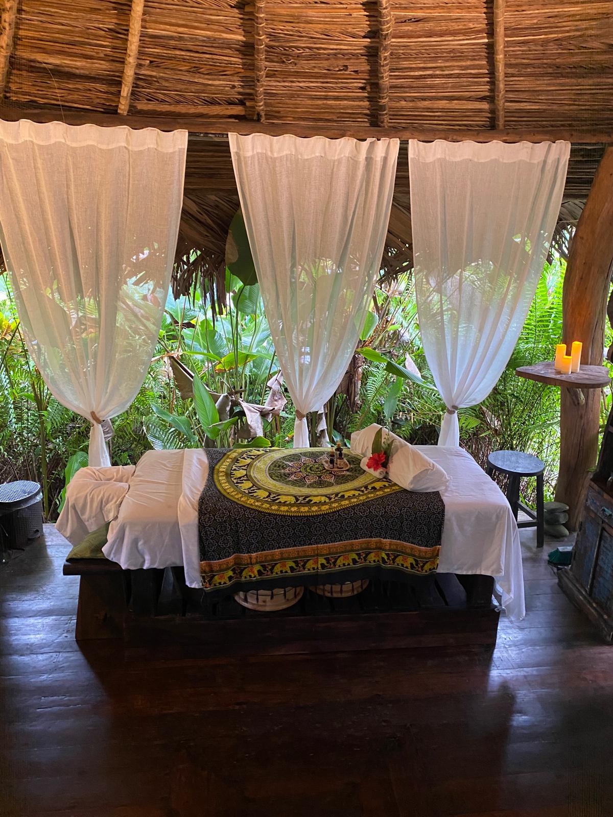 Couples massage setup inside the open-air rainforest cabana